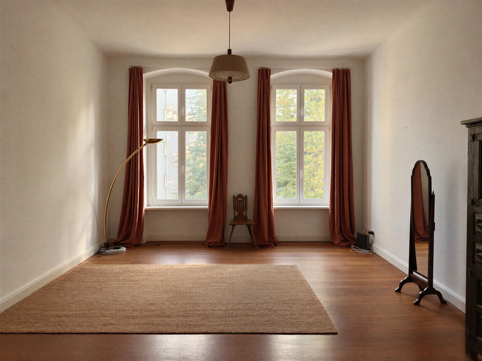 Bedroom with wood flooring, tall windows and rust-colored curtains